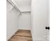 Bright walk-in closet with shelving and wood-look flooring adds functionality to the space at 3230 Rogers St, Charlotte, NC 28208
