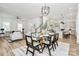 Open-concept space features a glass dining table, seamlessly blending dining and living areas, with a view into the kitchen at 3230 Rogers St, Charlotte, NC 28208