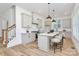 Modern kitchen boasts an island with seating, white cabinets, stainless steel appliances, and stylish pendant lighting at 3230 Rogers St, Charlotte, NC 28208