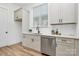Well-lit kitchen with stainless steel dishwasher, under-mount sink, and white cabinetry at 3230 Rogers St, Charlotte, NC 28208