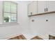 Efficient laundry room with upper cabinets, wash basin and window at 3230 Rogers St, Charlotte, NC 28208