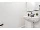 Stylish powder room featuring a pedestal sink, sleek faucet, and a contemporary mirror at 3230 Rogers St, Charlotte, NC 28208