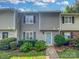 Charming townhome featuring a light blue front door, gray siding and well-maintained landscaping at 6003 Heath Valley Rd, Charlotte, NC 28210