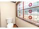 Simple bathroom with stained glass window and toilet at 903 W Franklin St, Monroe, NC 28112