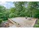 Custom stone patio backing to mature trees provides a private backyard space for relaxing and entertaining at 3020 Poplar Hill Rd, Charlotte, NC 28270