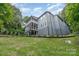 Three-story home with gray siding, multiple decks, and a retaining wall overlooking a spacious backyard at 3020 Poplar Hill Rd, Charlotte, NC 28270