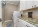 Laundry room equipped with side-by-side washer and dryer, complemented by granite countertops and white cabinetry at 3020 Poplar Hill Rd, Charlotte, NC 28270
