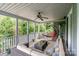 Screened porch with comfortable seating, ceiling fan, and view of the wooded surroundings, perfect for outdoor relaxation at 3020 Poplar Hill Rd, Charlotte, NC 28270