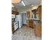 Kitchen with wood cabinets, tile flooring, and white appliances at 4817 Mossy Cup Ln, Monroe, NC 28110