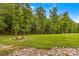 Spacious backyard featuring a fire pit surrounded by a grassy lawn and trees at 127 Tradition Ln, Mooresville, NC 28115