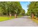 A long driveway leads to a gated entrance, surrounded by lush greenery at 127 Tradition Ln, Mooresville, NC 28115