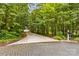 Long, private driveway leading to a house obscured by dense trees at 127 Tradition Ln, Mooresville, NC 28115