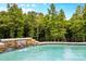 Beautiful pool featuring a waterfall and lush green trees surrounding the fenced in backyard at 127 Tradition Ln, Mooresville, NC 28115