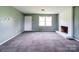 Large living room with neutral carpeting, a painted brick fireplace, and natural light at 131 Sam Smith Rd, Kings Mountain, NC 28086