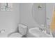 Bathroom with sink, toilet, mirror, and fun artwork at 12119 Brooklyn Ave, Charlotte, NC 28204