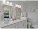 Light and bright bathroom with double sinks, white cabinets, quartz counters, and framed mirrors at 12119 Brooklyn Ave, Charlotte, NC 28204