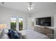 Neutral bedroom boasts hardwood floors, ceiling fan, a TV, and a dresser at 12119 Brooklyn Ave, Charlotte, NC 28204