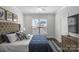 A serene bedroom with a tufted headboard and ample natural light from window at 12119 Brooklyn Ave, Charlotte, NC 28204