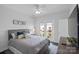 Bright bedroom features a large bed, private balcony, and neutral paint at 12119 Brooklyn Ave, Charlotte, NC 28204