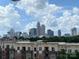 Breathtaking view of the Charlotte skyline from atop a modern multi-story residence on a partly cloudy day at 12119 Brooklyn Ave, Charlotte, NC 28204