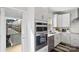 Modern kitchen boasts stainless steel appliances, white cabinets, a view of an exterior balcony and natural light at 12119 Brooklyn Ave, Charlotte, NC 28204