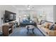 Bright living room boasts modern furniture, a ceiling fan, and a large TV above wood cabinet at 12119 Brooklyn Ave, Charlotte, NC 28204