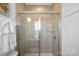 Modern shower features glass doors, neutral tile, and sleek fixtures at 12119 Brooklyn Ave, Charlotte, NC 28204