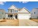 Two-story house with a white and gray exterior, two-car garage, and landscaped yard at 8611 Frank Grier Rd # 1, Charlotte, NC 28215
