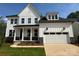 New two story home boasts white siding, a black roof, a two car garage, and a charming front porch at 5225 Glenwalk Dr # 0061, Charlotte, NC 28269