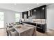 Modern kitchen features a center island with seating, sleek black cabinetry, and elegant marble backsplash at 5225 Glenwalk Dr # 0061, Charlotte, NC 28269