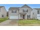 Two-story house with gray siding, a white garage door, and a landscaped lawn at 1608 Cannonball Ln, Bessemer City, NC 28016
