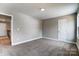 Bright bedroom with neutral walls and carpet, featuring a door and window at 822 N Rocky River Rd, Monroe, NC 28110