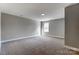 Well-lit bedroom with neutral walls and carpet, and a window at 822 N Rocky River Rd, Monroe, NC 28110