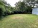 Large grassy backyard surrounded by trees offering privacy at 647 Reeves Ct, Charlotte, NC 28208