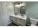 Bathroom with double vanity, arched mirrors, and updated fixtures at 647 Reeves Ct, Charlotte, NC 28208