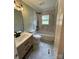 Updated bathroom features a soaking tub, modern vanity, and stylish tile at 647 Reeves Ct, Charlotte, NC 28208