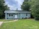 Newly renovated light blue house with a well-maintained lawn at 647 Reeves Ct, Charlotte, NC 28208