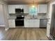 Modern white kitchen with stainless steel appliances and granite countertops at 647 Reeves Ct, Charlotte, NC 28208