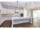 Modern kitchen with white cabinets, marble island, and stainless steel appliances at 1025 Patterson Farm Rd, Mooresville, NC 28115