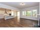 Spacious living room with hardwood floors and large windows overlooking wooded backyard at 1025 Patterson Farm Rd, Mooresville, NC 28115