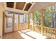 Spacious screened porch with wooden deck and ceiling fan, overlooking wooded area at 1025 Patterson Farm Rd, Mooresville, NC 28115