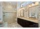 Elegant bathroom with dual vanities, a large shower, and patterned wallpaper at 16015 Vale Ridge Dr # 133, Charlotte, NC 28278