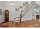 Bright entry with hardwood floors, curved staircase, and grandfather clock at 16015 Vale Ridge Dr # 133, Charlotte, NC 28278