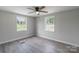 Bedroom featuring hardwood floors, ceiling fan, and two windows with natural light at 55 Shannon Park Cir, Taylorsville, NC 28681
