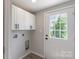 Functional laundry room with white cabinets and a bright window at 55 Shannon Park Cir, Taylorsville, NC 28681