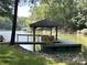 Lakefront dock with a boat slip and serene waterfront views of the surrounding trees at 301 Agnew Rd, Mooresville, NC 28117