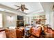 Living room with a stone fireplace, leather seating, ceiling fan, and modern decor creating a cozy atmosphere at 301 Agnew Rd, Mooresville, NC 28117