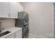 Well-appointed laundry room with stacked washer and dryer, and white cabinets at 170 Old Post Rd, Mooresville, NC 28117