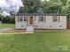 Charming ranch home with white brick facade, wood shutters, and landscaped lawn at 2626 Abelwood Rd, Charlotte, NC 28216