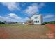 Rear of home with a covered deck and a spacious backyard, set against a blue sky with scattered clouds at 4808 Glen Stripe Dr # Cal0036, Indian Trail, NC 28079